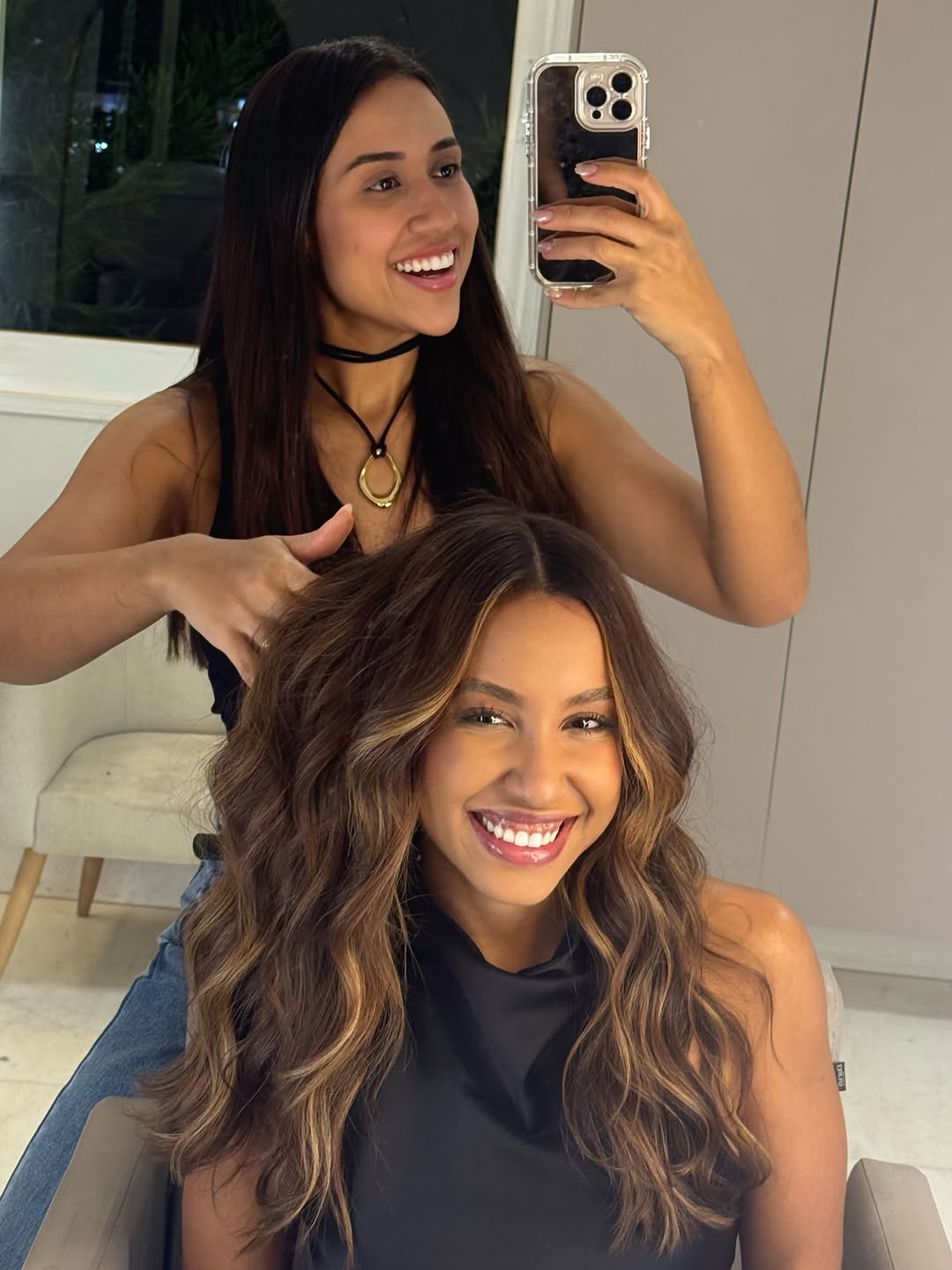 Mega hair castanho iluminado com ondas, cliente sorrindo durante o atendimento